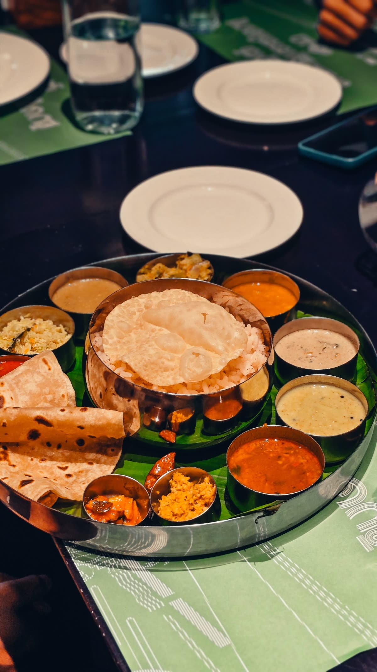 Full vegetarian thali spread with rice, poori and curries